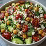 Freshly tossed High Protein Quinoa & Chickpea Salad topped with crumbled feta, parsley, and lemon dressing.