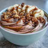A spoon-ready Chocolate Peanut Butter Smoothie Bowl, drizzled with extra peanut butter and perfect for breakfast or snack time.