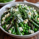 A close-up of Spring Green Bowl topped with fresh herbs and lemon zest.