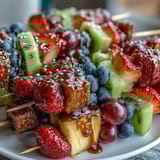 Fresh, juicy fruit skewers arranged in rainbow order, served with a creamy honey-lemon yogurt dip for a refreshing summer treat.  