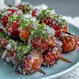 Vibrant frozen grapes sparkle on wooden skewers, coated in tangy lime sugar for a sweet-tart treat that's easy to prepare and serve.