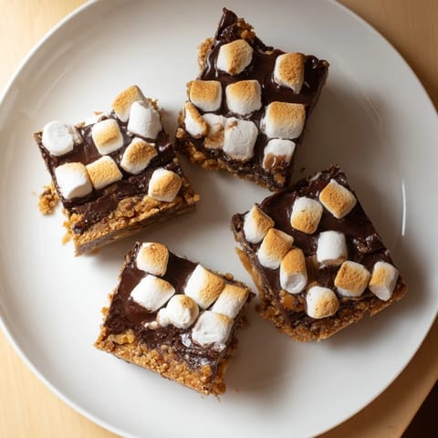 Freshly baked S'mores Bars sit on a rustic wooden board with melted chocolate and toasted marshmallow swirls.