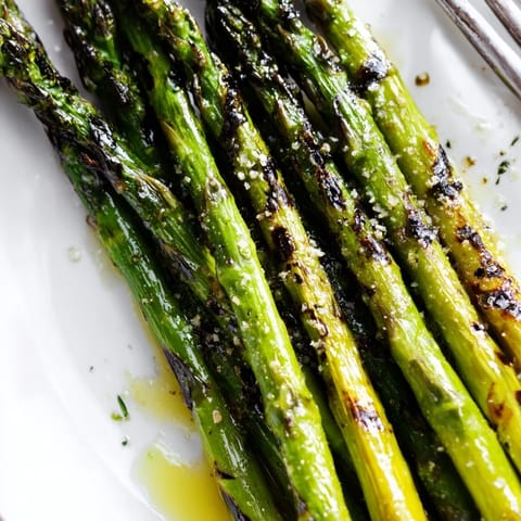 Perfectly charred Grilled Asparagus, lightly seasoned and ready to serve alongside grilled salmon or steak for a simple side.