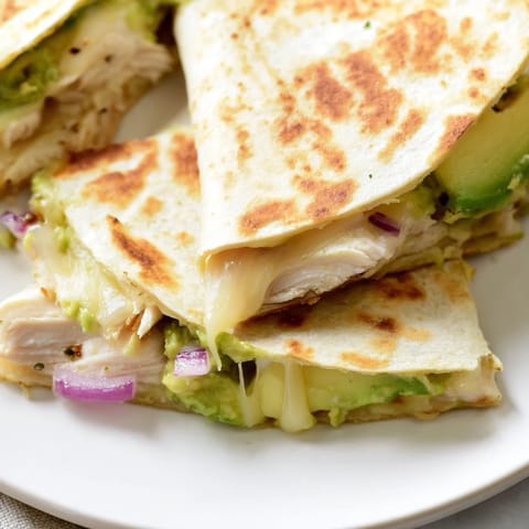 Grilled chicken and avocado quesadilla served warm with a side of salsa for dipping.  