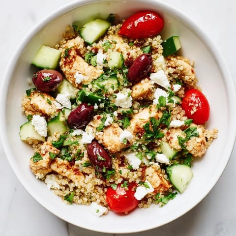 Fresh Mediterranean Chicken Bowl topped with cucumbers, tomatoes, and parsley, ready for a healthy lunch.