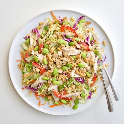Close-up of Edamame Crunch Chicken Salad with edamame, sliced red bell pepper, and toasted sesame seeds, ready for a light lunch or dinner.