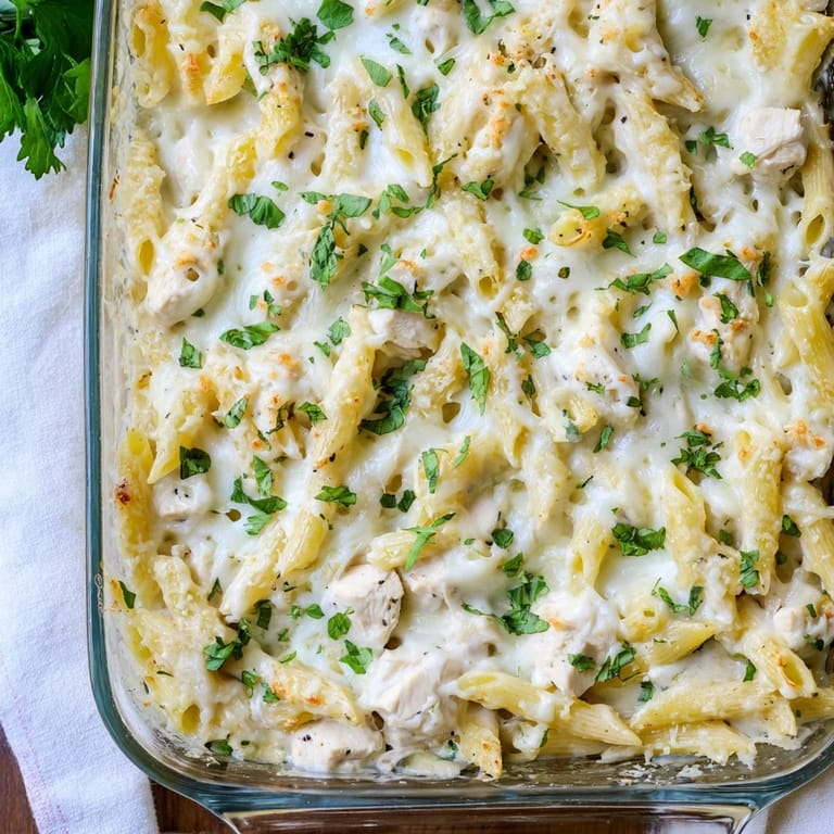 Creamy Chicken Alfredo Bake served hot with fresh parsley garnish and steam rising.