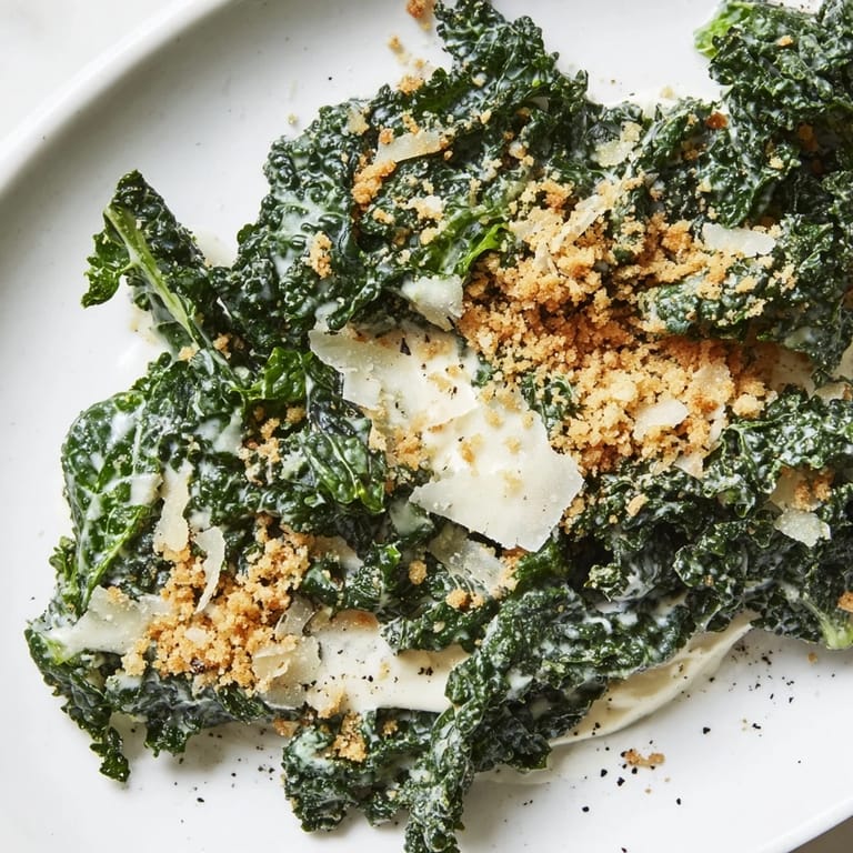 Massaged kale tossed in a tangy garlic Parmesan dressing, served as a hearty vegetarian side.