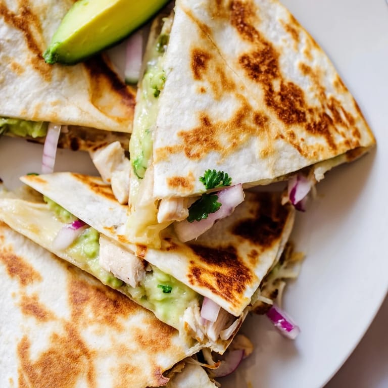 Crispy Chicken Avocado Quesadilla cut into triangles, showcasing juicy chicken and Monterey Jack cheese.