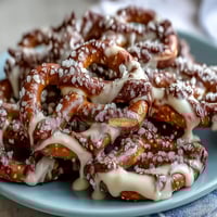Festive St. Patricks Day Shamrock Pretzel Bites with white chocolate drizzle and green sprinkles for a sweet-salty holiday treat.